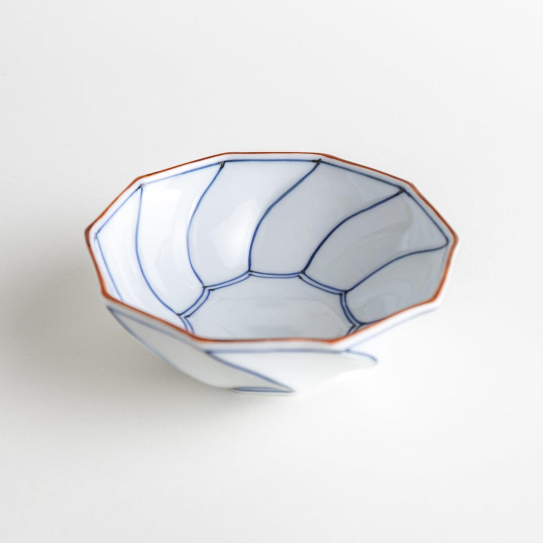 Deep white octagonal dessert bowl with a petal design, outlined in blue or red and finished with a brown rim.