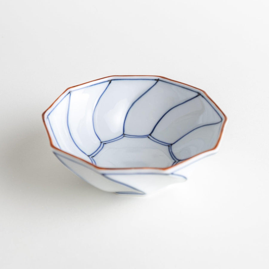 Deep white octagonal dessert bowl with a petal design, outlined in blue or red and finished with a brown rim.