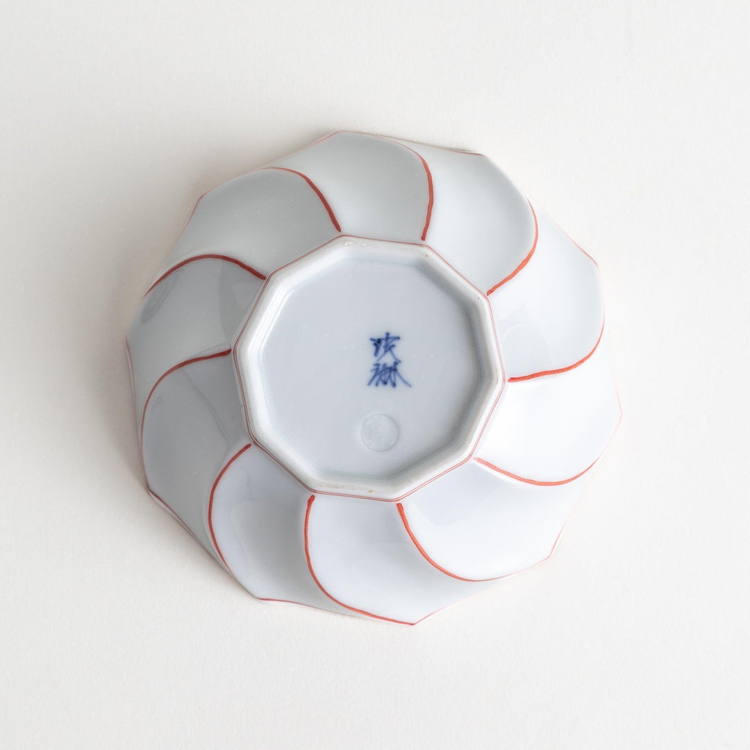 Deep white octagonal dessert bowl with a petal design, outlined in blue or red and finished with a brown rim.