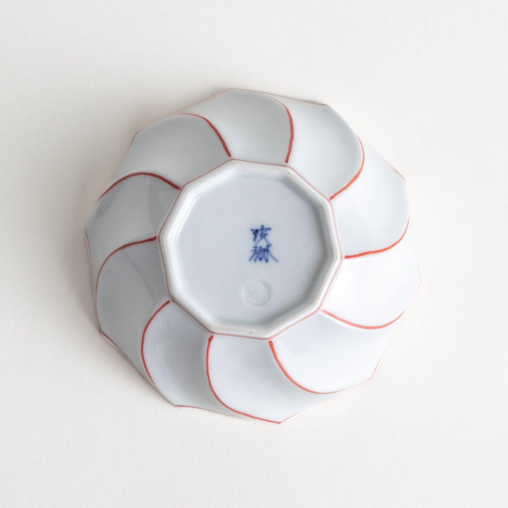 Deep white octagonal dessert bowl with a petal design, outlined in blue or red and finished with a brown rim.