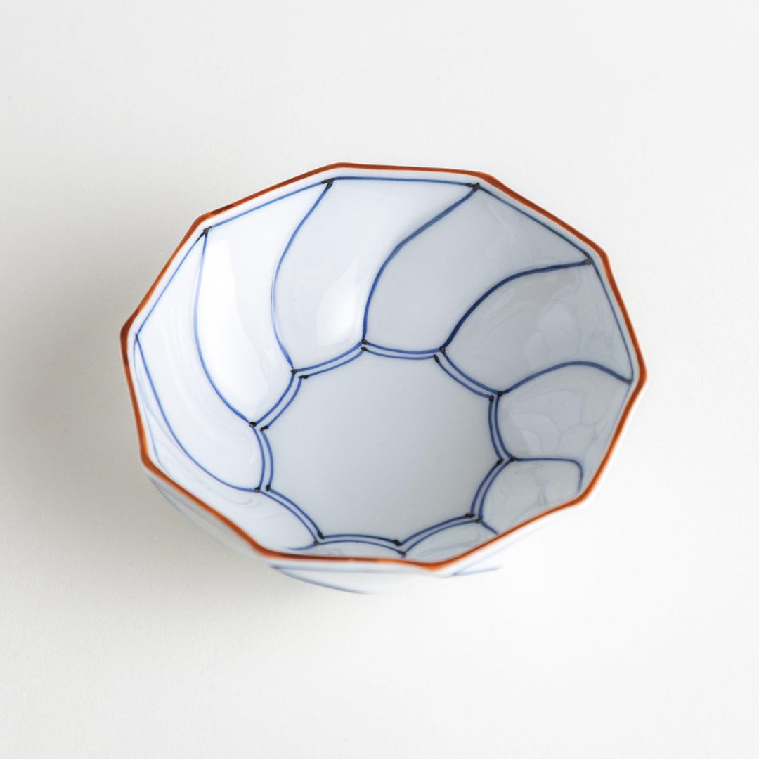Deep white octagonal dessert bowl with a petal design, outlined in blue or red and finished with a brown rim.