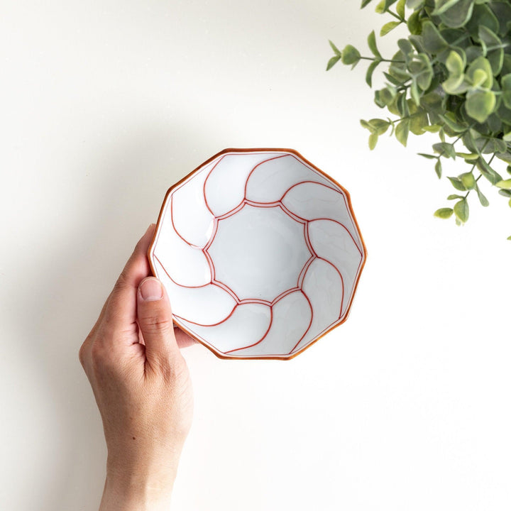Deep white octagonal dessert bowl with a petal design, outlined in blue or red and finished with a brown rim.