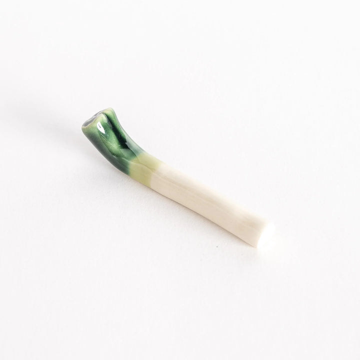 Slightly angled view of the glossy green onion chopsticks rest, showcasing its smooth ceramic finish.
