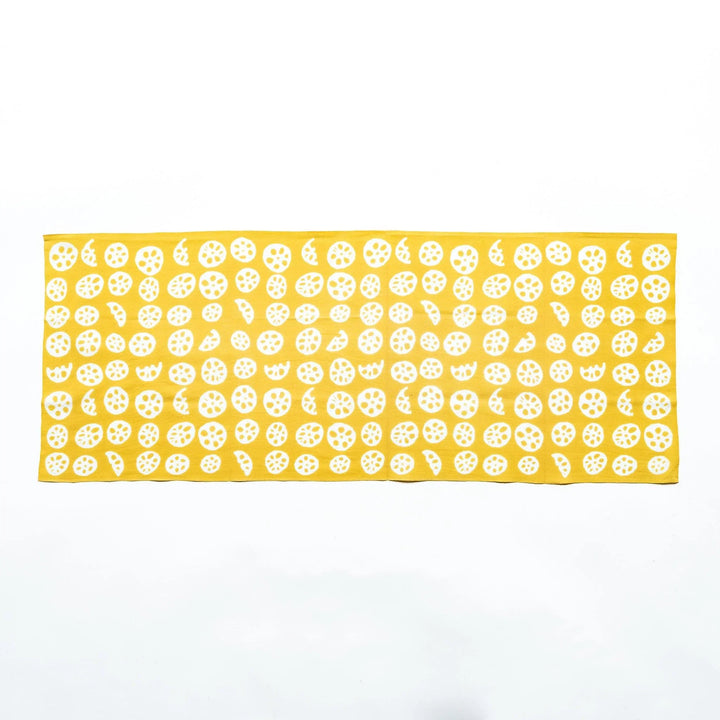 Yellow hand towel showcasing white lotus root slice patterns, fully spread.