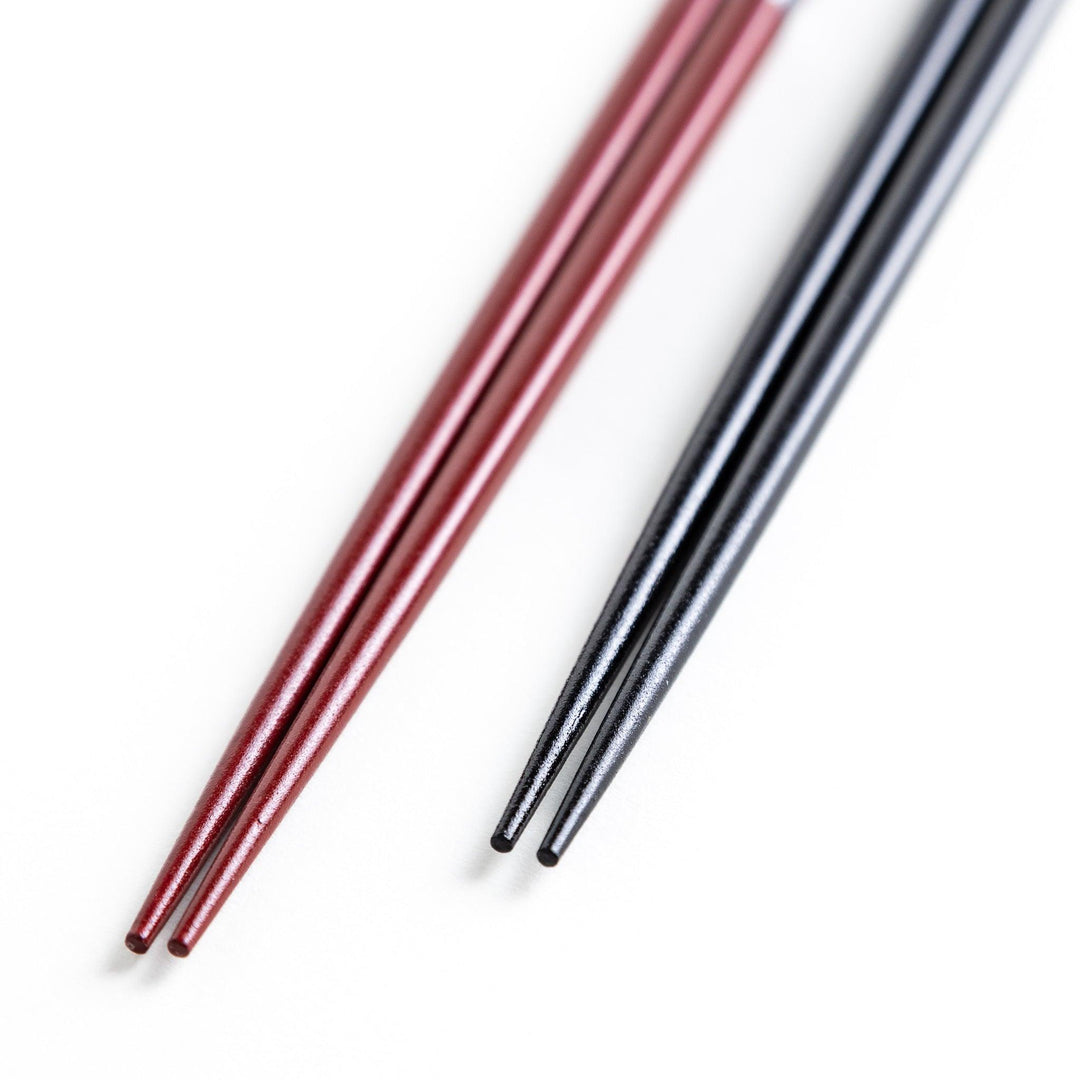 A boxed set of two pairs of chopsticks, one with a black and one with crane patterns on the handles.