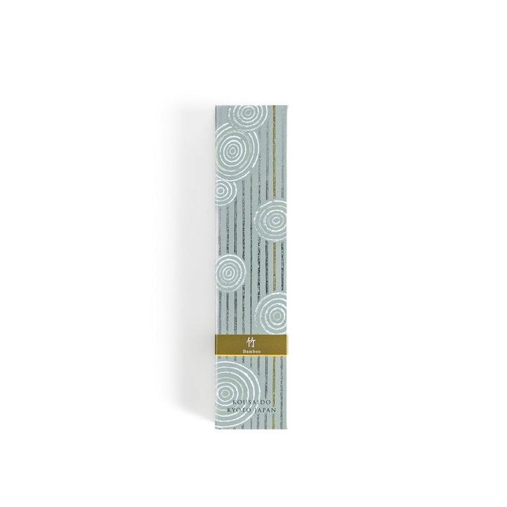Green incense sticks in a light wooden box with soft green packaging featuring white circular patterns design.