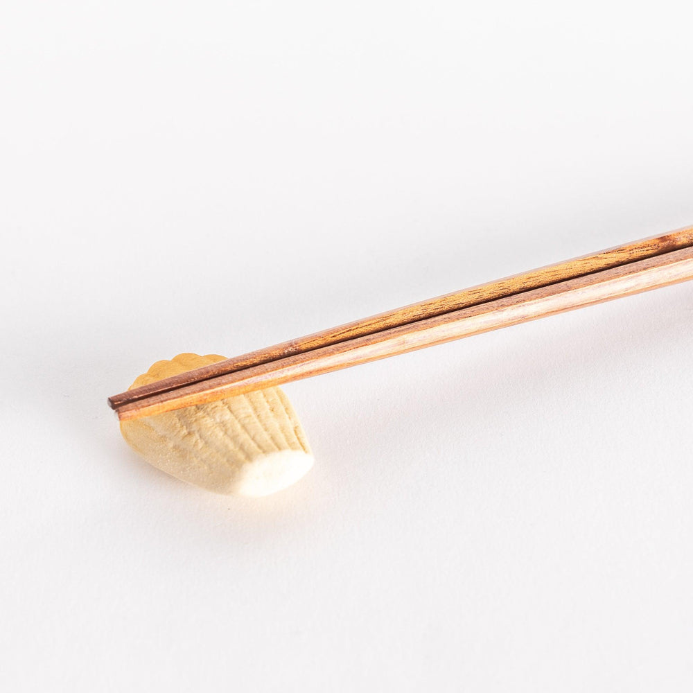 Madeleine shaped ceramic chopstick rest with soft golden tone adding sweet charm to table setting.