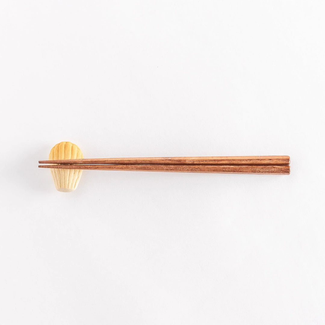 Madeleine shaped ceramic chopstick rest with soft golden tone adding sweet charm to table setting.