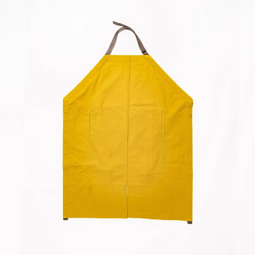 Stylish mustard yellow Japanese apron from our kitchen linens collection, featuring pockets and adjustable straps.