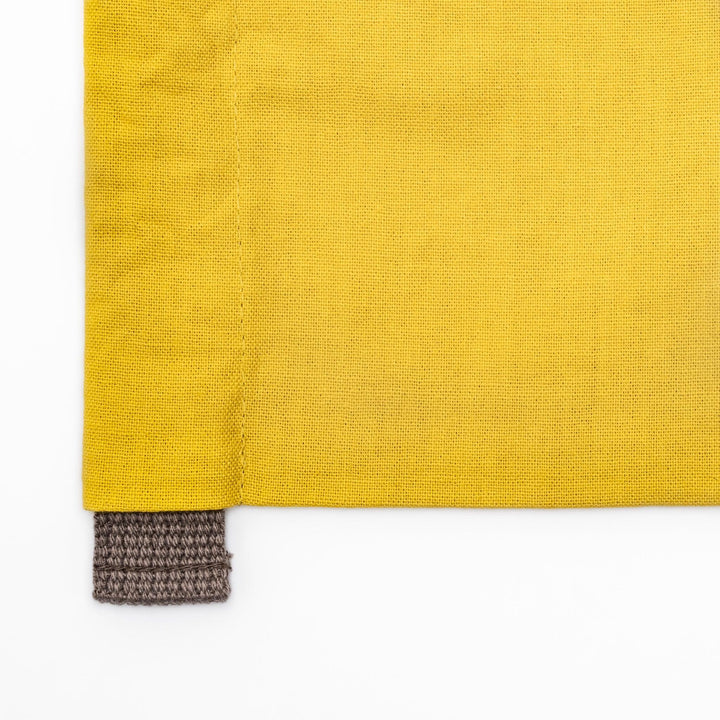 Stylish mustard yellow Japanese apron from our kitchen linens collection, featuring pockets and adjustable straps.