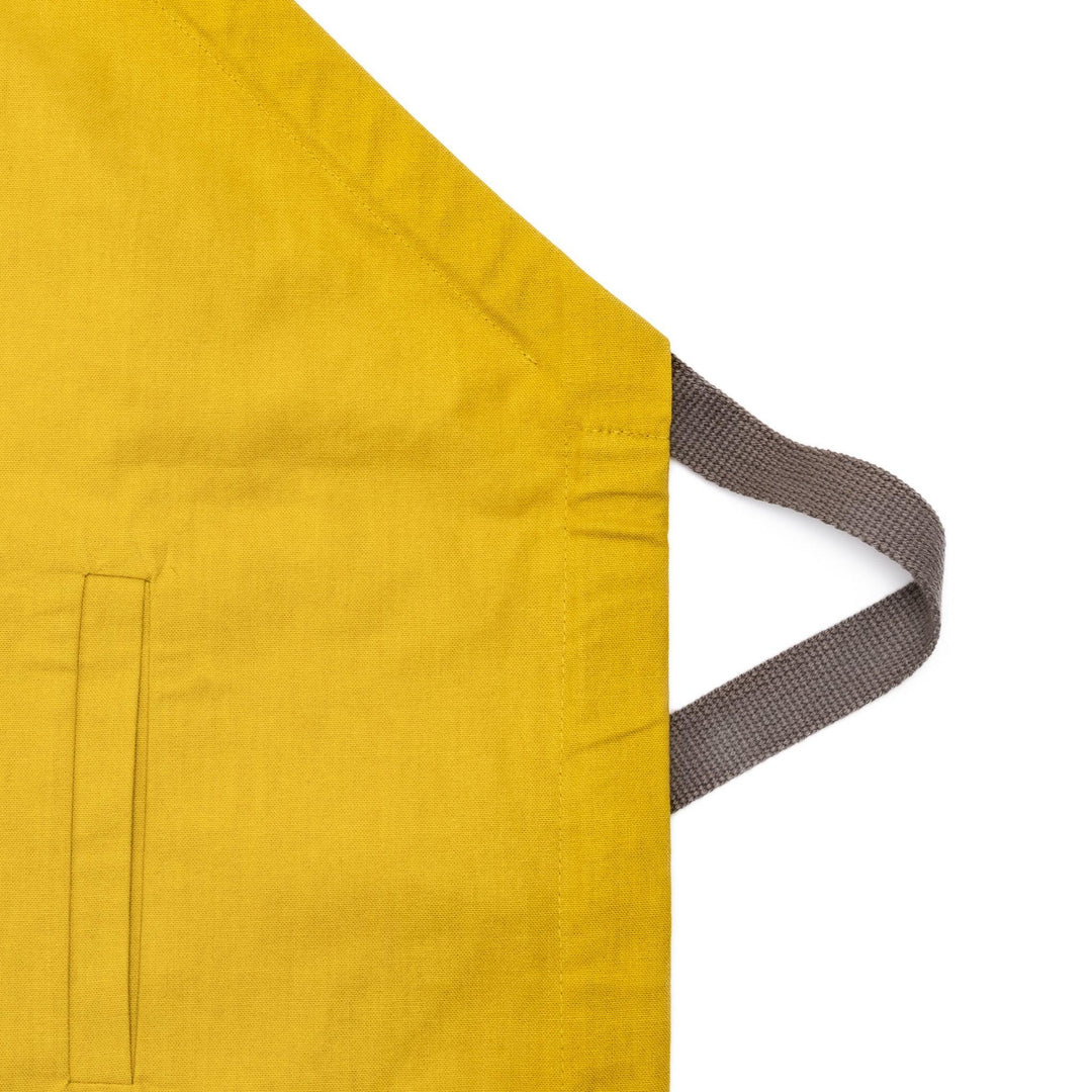 Stylish mustard yellow Japanese apron from our kitchen linens collection, featuring pockets and adjustable straps.