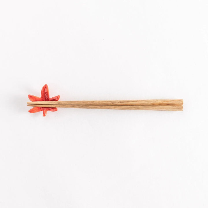 Chopsticks resting on the maple leaf chopsticks rest, full view from above.