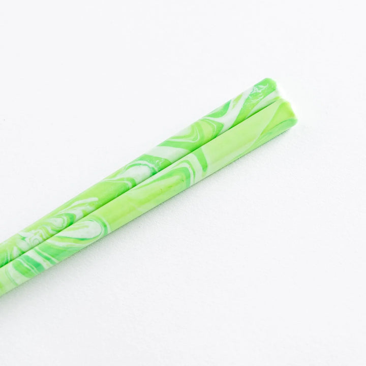 Close-up of mint green and white marble chopsticks, showing their smooth finish and stylish design