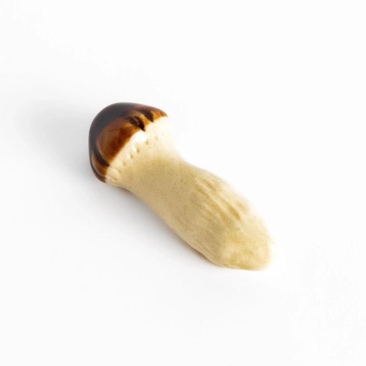 Japanese ceramic matsutake mushroom chopstick rest adding natural charm and elegance to dining table setting.