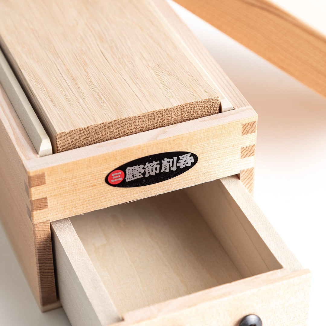 Japanese wooden katsuobushi shaver box with drawer and lid for bonito flakes featuring traditional artwork.