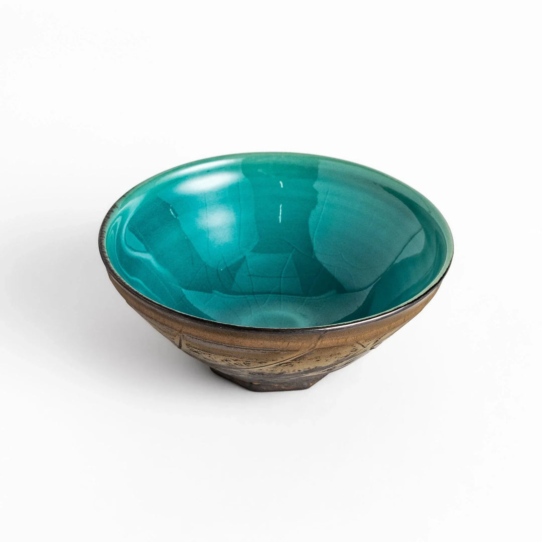 Textured brown Matcha bowl with a bright green interior, handcrafted ceramic for modern tea rituals.
