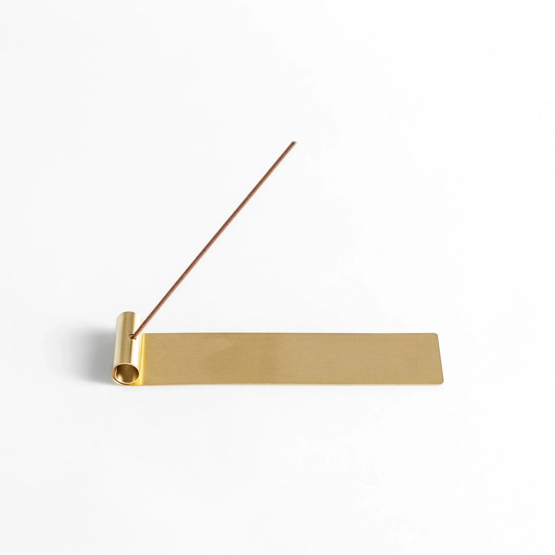 Brass incense holder with rolled-edge design and flat base, securely holding incense while catching ash. (118)