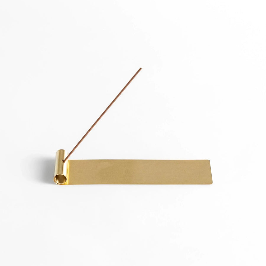 Brass incense holder with rolled-edge design and flat base, securely holding incense while catching ash. (118)