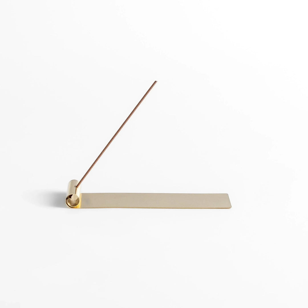 Brass incense holder with rolled-edge design and flat base, securely holding incense while catching ash. (118)