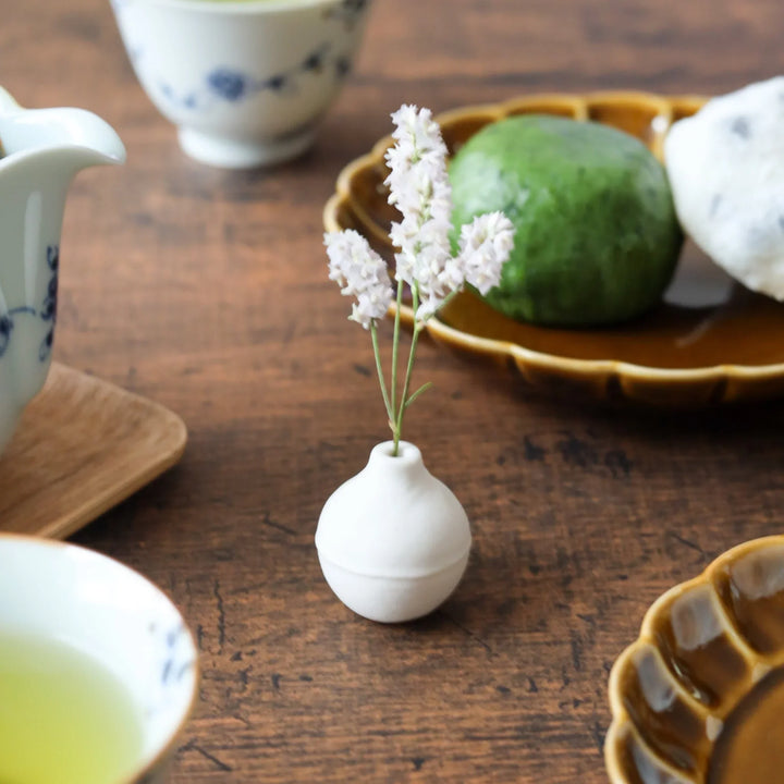 White ceramic bud vase with dried flowers, perfect for adding simple, elegant Japanese-inspired decor to any space.