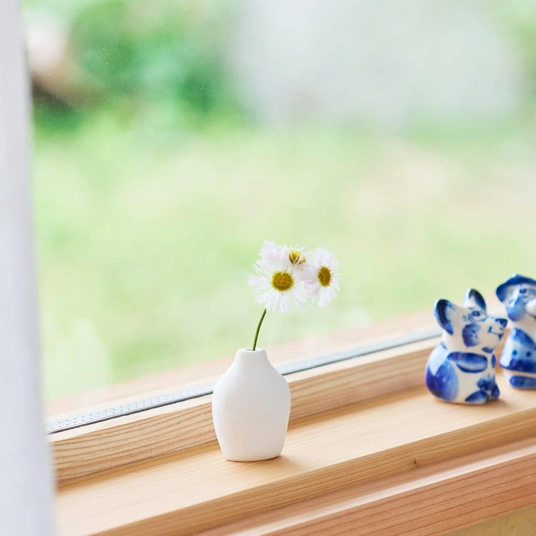 White ceramic bud vase with dried flowers, perfect for adding simple, elegant Japanese-inspired decor to any space.