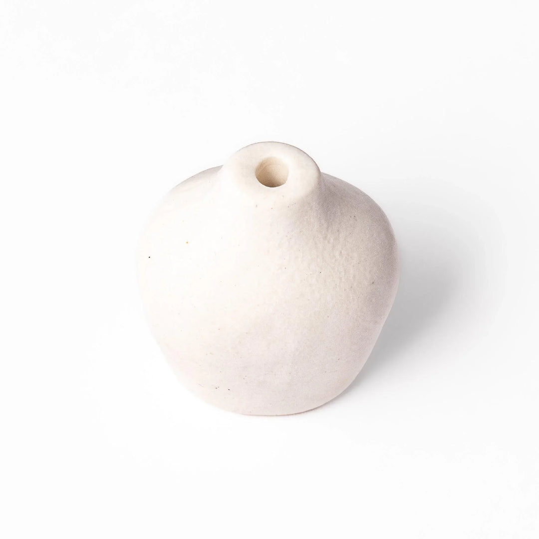 White ceramic bud vase with dried flowers, perfect for adding simple, elegant Japanese-inspired decor to any space.