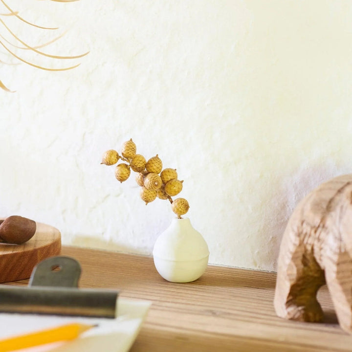 White ceramic bud vase with dried flowers, perfect for adding simple, elegant Japanese-inspired decor to any space.