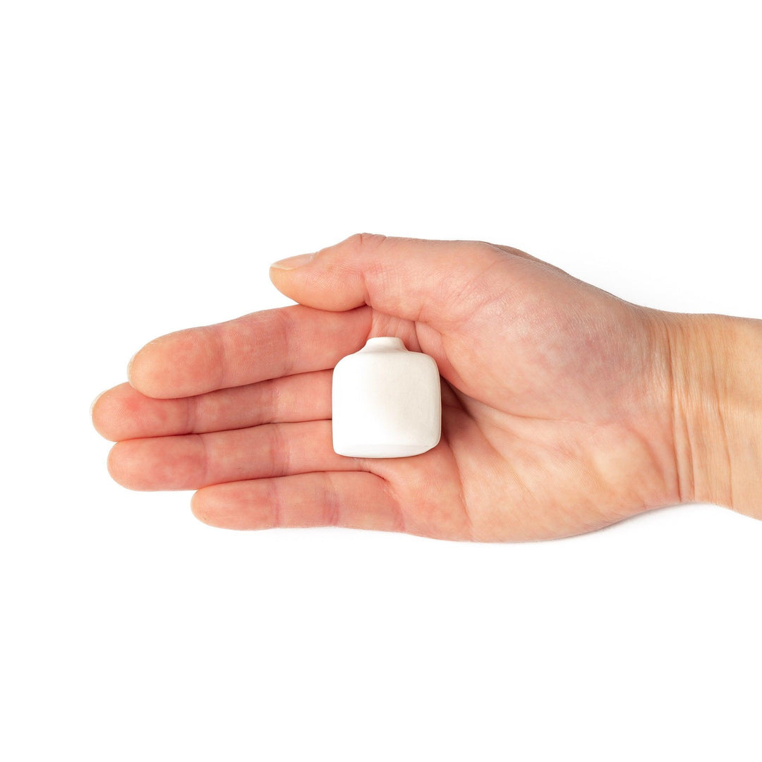 White ceramic bud vase with dried flowers, perfect for adding simple, elegant Japanese-inspired decor to any space.