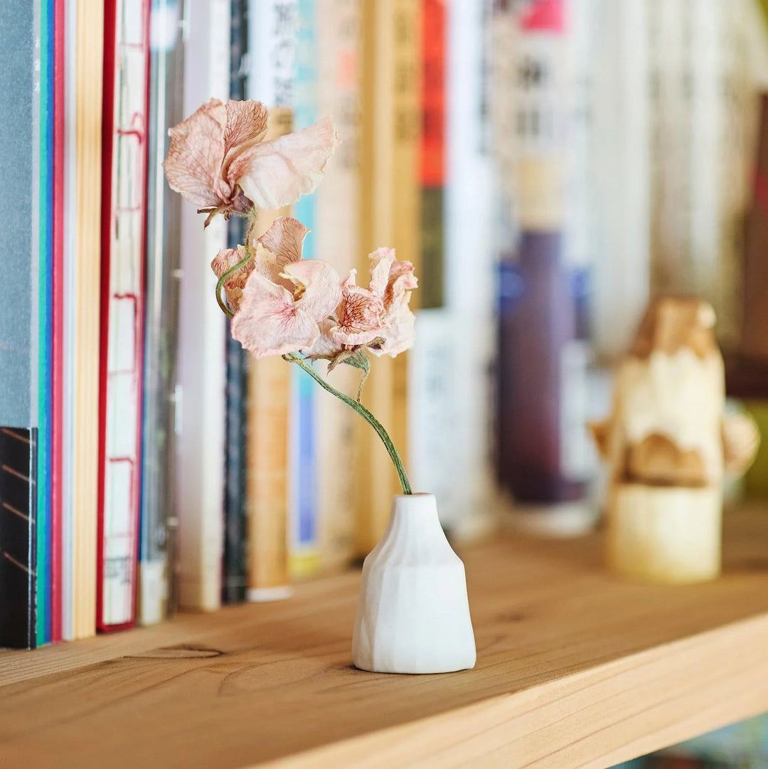White ceramic bud vase with dried flowers, perfect for adding simple, elegant Japanese-inspired decor to any space.