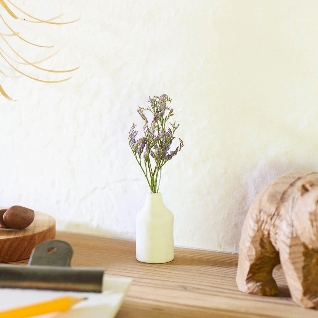 White ceramic bud vase with dried flowers, perfect for adding simple, elegant Japanese-inspired decor to any space.