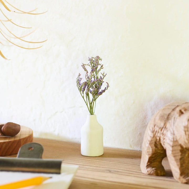White ceramic bud vase with dried flowers, perfect for adding simple, elegant Japanese-inspired decor to any space.