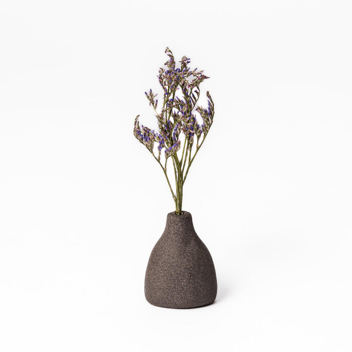 Dark ceramic bud vase with dried flowers, ideal for bringing a modern Japanese touch to any room or table.