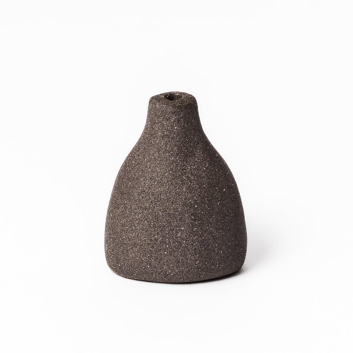 Dark ceramic bud vase with dried flowers, ideal for bringing a modern Japanese touch to any room or table.