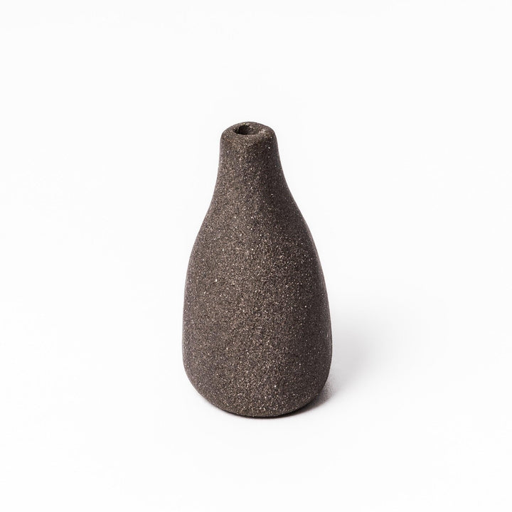 Dark ceramic bud vase with dried flowers, ideal for bringing a modern Japanese touch to any room or table.
