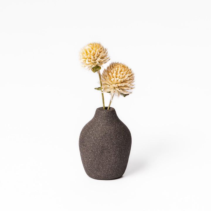Dark ceramic bud vase with dried flowers, ideal for bringing a modern Japanese touch to any room or table.
