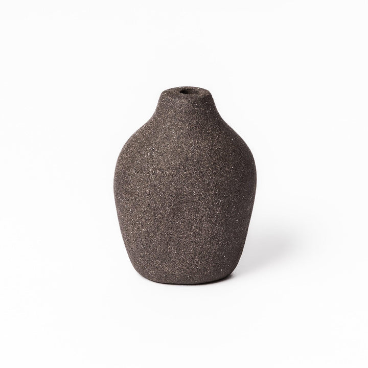 Dark ceramic bud vase with dried flowers, ideal for bringing a modern Japanese touch to any room or table.