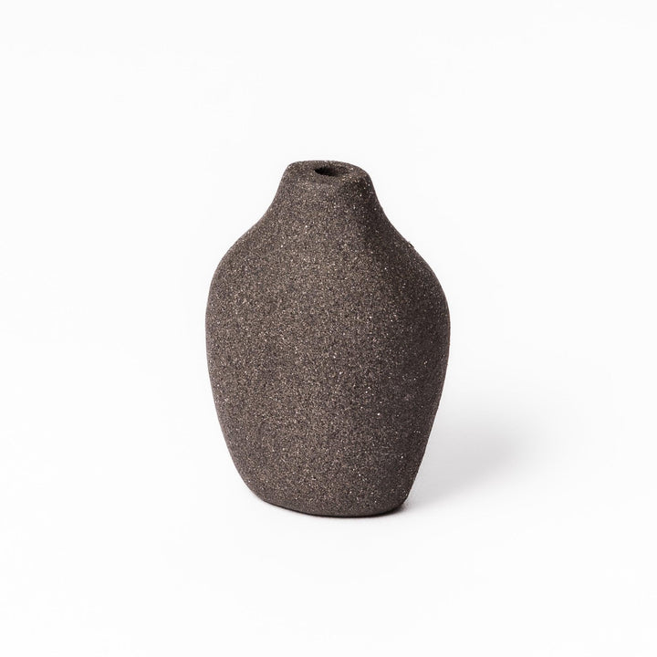 Dark ceramic bud vase with dried flowers, ideal for bringing a modern Japanese touch to any room or table.