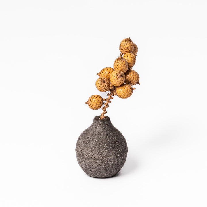 Dark ceramic bud vase with dried flowers, ideal for bringing a modern Japanese touch to any room or table.