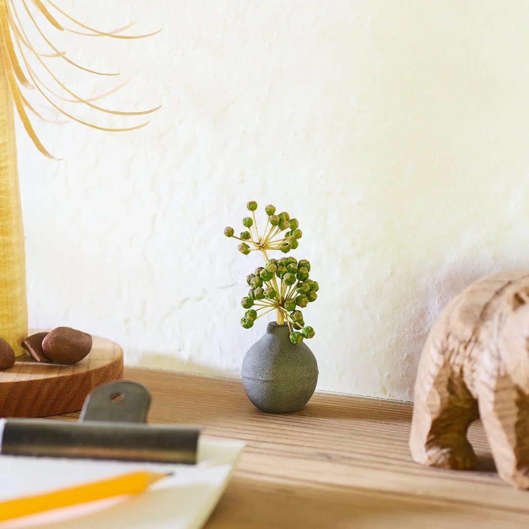 Dark ceramic bud vase with dried flowers, ideal for bringing a modern Japanese touch to any room or table.