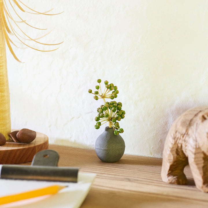 Dark ceramic bud vase with dried flowers, ideal for bringing a modern Japanese touch to any room or table.