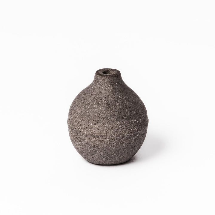 Dark ceramic bud vase with dried flowers, ideal for bringing a modern Japanese touch to any room or table.