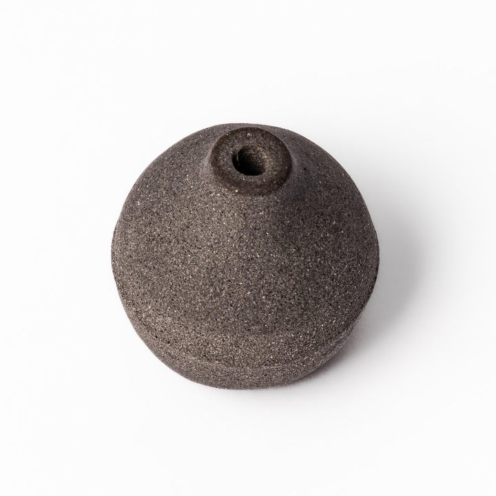 Dark ceramic bud vase with dried flowers, ideal for bringing a modern Japanese touch to any room or table.