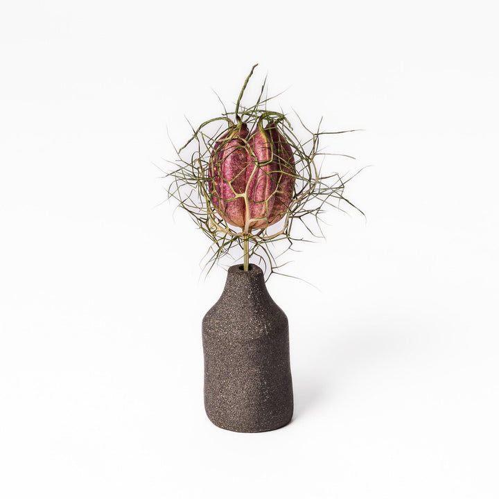 Dark ceramic bud vase with dried flowers, ideal for bringing a modern Japanese touch to any room or table.