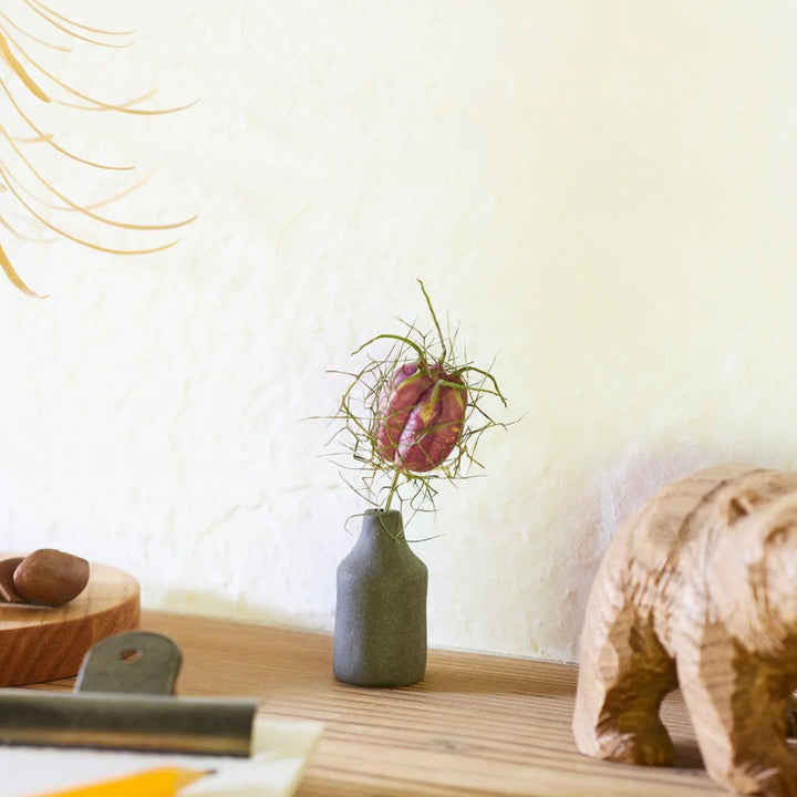 Dark ceramic bud vase with dried flowers, ideal for bringing a modern Japanese touch to any room or table.