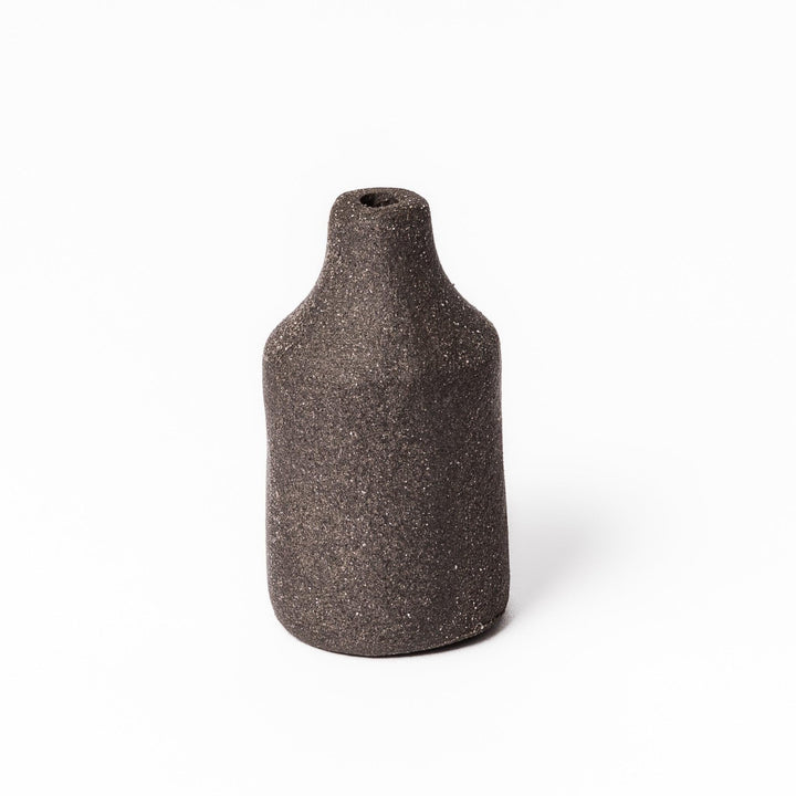 Dark ceramic bud vase with dried flowers, ideal for bringing a modern Japanese touch to any room or table.