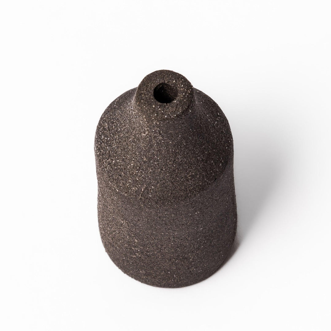 Dark ceramic bud vase with dried flowers, ideal for bringing a modern Japanese touch to any room or table.