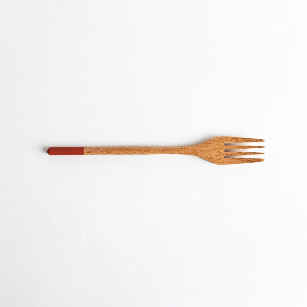 A set of four wooden pasta fork, each with a different colored tip—white, black, blue, and red.
