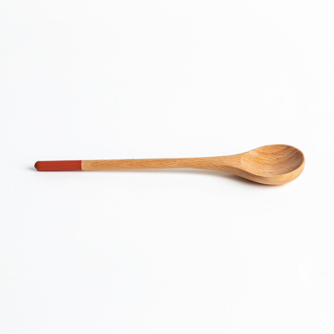 A set of four wooden soup spoons with wide, rounded bowls and colored tips—white, black, blue, and red.