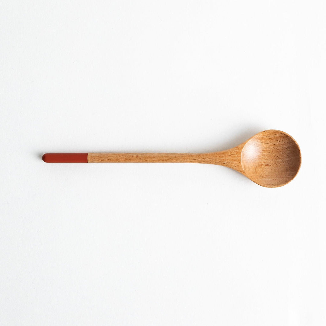A set of four wooden soup spoons with wide, rounded bowls and colored tips—white, black, blue, and red.