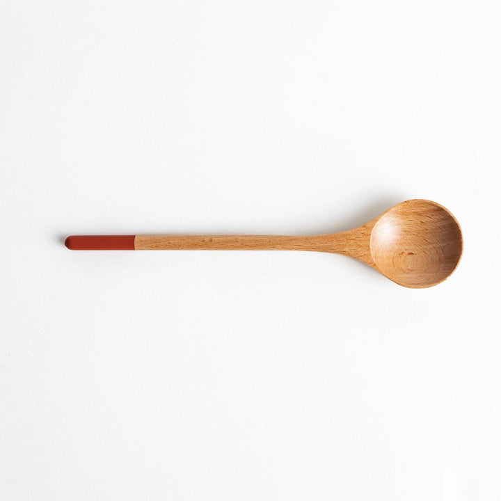 A set of four wooden soup spoons with wide, rounded bowls and colored tips—white, black, blue, and red.